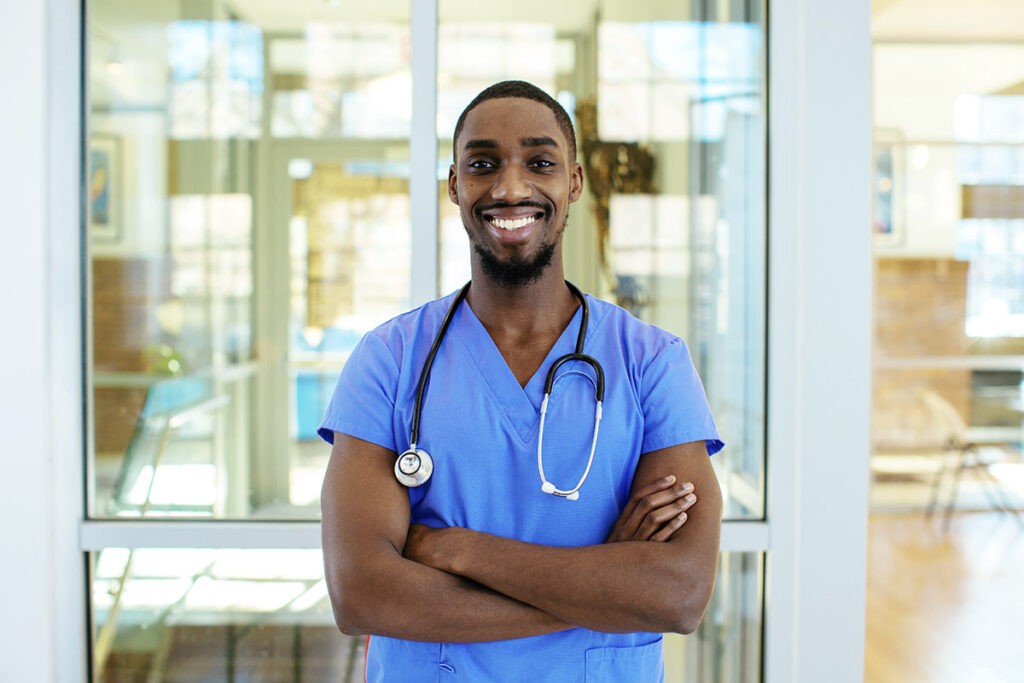 Friendly male nurse wearing blue scrubs.